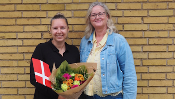 FOA Odenses formand Nina Skov-Lauridsen lykønsker velfærdstalent Stephanie Rasmussen med flag og buket